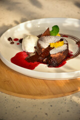Gourmet chocolate lava brownie filled with warm melted chocolate, served with a scoop of ice cream. The rich chocolate sauce is visibly oozing from the center, creating a mouthwatering and indulgent v