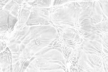 White water with ripples on the surface. Defocus blurred transparent white colored clear calm water surface texture with splashes and bubbles. Water waves with shining pattern texture background.