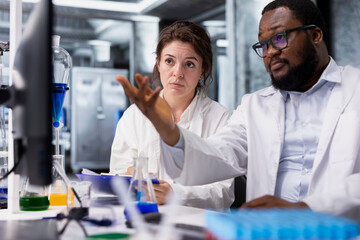 Diagnostic laboratory manager showing intern genetic markers associated with disease risk on PC....