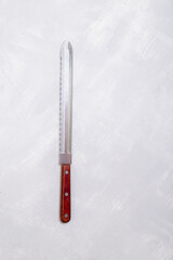 Vintage Serrated Bread Knife on Textured Gray Background