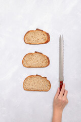 Overhead View of Three Bread Slices with Vintage Bread Knife and Hand