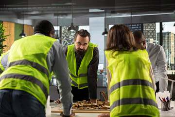 Property developers and architects in business meeting reviewing blueprints and structural designs....