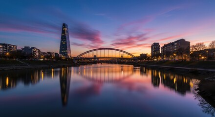 Naklejka premium A stunning urban river scene during the colorful twilight hour with modern infrastructure reflecting in the calm flowing water ,blue ,metropolis ,natural beauty