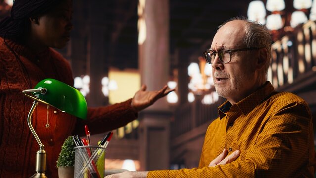 Senior adult in hyperventilation crisis feeling unwell in the campus library, having difficulty breathing and showing vulnerability. Old student having a panic attack emergency.