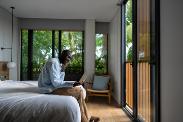 African american black man working on a laptop in a tropical-inspired home office