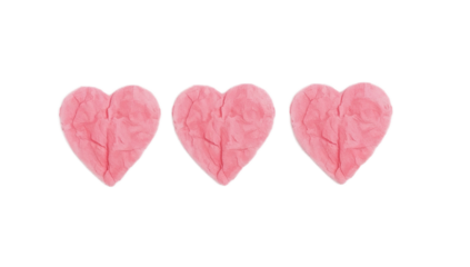 Three pink heart-shaped sculptures made of clay, isolated on a white background, symbolizing love and affection
