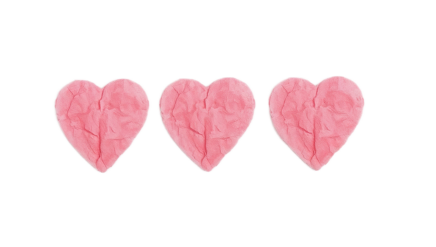 Three pink heart-shaped sculptures made of clay, isolated on a white background, symbolizing love and affection
