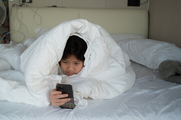 kid watching tablet on the bed, child addicted cartoon