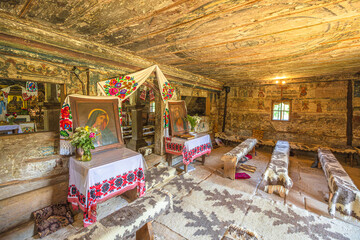 Maramures, Romania - Aug 13, 2025: Interior of Surdesti wooden Greek-Catholic church of Archangels Michael and Gabriel in Maramures, ornate painted ceilings, icons and traditional folk art landmark