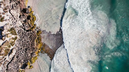 Ocean waves crash against rocky shore creating a stunning coastal landscape at the beach