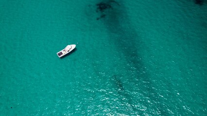 Sailing on clear turquoise waters with a small boat enjoying the serene ocean view at midday