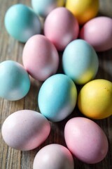 Overhead View of a Rustic Easter Table Setting with Pastel Eggs and Spring Florals Overhead flat lay view of a rustic wooden table with a textured surface. Decorated with several pastel colored Easter