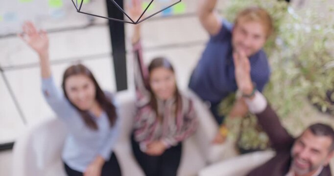 Successful business team stacking hands together. Colleagues celebrating and smiling in an office.