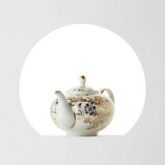 A white porcelain teapot with gold floral pattern, isolated on a cut out background.