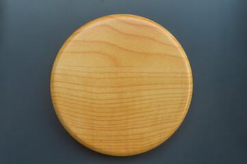 Top view of a blank circular wooden with visible wood grain texture, isolated on a dark gray background. Ideal mockup for product display, food presentation, and minimal design.