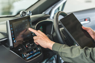 Male auto mechanic using a tablet device inside a car
