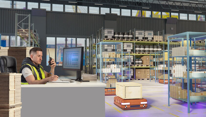 Warehouse operator in safety vest monitors automated robots moving crates, using computer and radio to control logistics and storage processes.