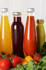 Bottles of different tasty sauces and products on grey wooden table, closeup