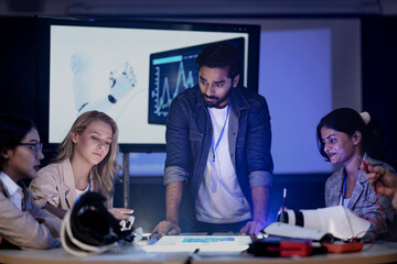 A robotics engineering team in an RD lab reviews a prototype. They are designing an AI powered robotic arm, analyzing data on a screen and a smart table.