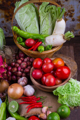 Assortment of Fresh Asian Vegetables, Spices, and Herbs on a Rustic Wooden Table.