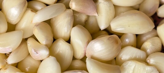 Peeled garlic cloves piled closely lightyellow hues