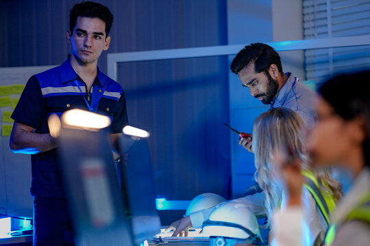 A female logistics manager coordinates operations using a radio in a smart factory. She is optimizing the supply chain with AI and Industry 4.0 technology.