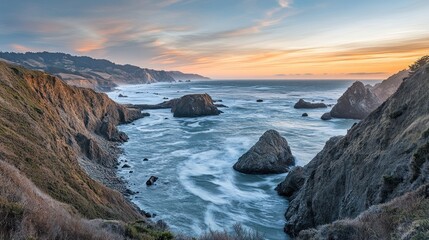 Dramatic coastal sunset view of rugged cliffs and waves crashing on rocks