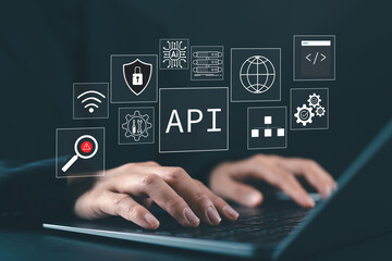 API Application Programming Interface Concept. Application Software Tool, A programmer types on a laptop, interacting with digital icons representing API development, security, and cloud computing.