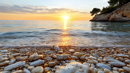 Golden sunset over calm sea, reflecting warm light on pebbled shore, creating serene atmosphere