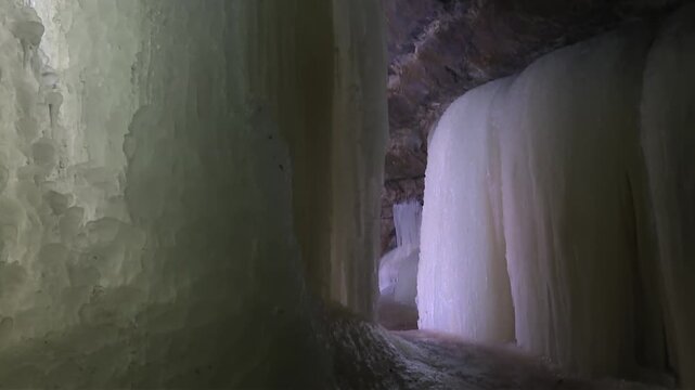 Massive, rounded ice formations line the interior passage of Eben Ice Caves in Michigan, USA