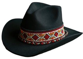 Black cowboy hat with intricate band on dark backdrop
