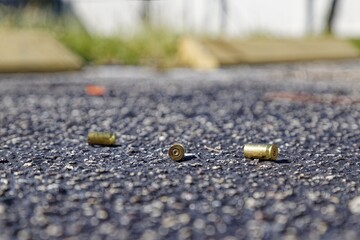 Three bullet casings on asphalt after shooting incident, USA