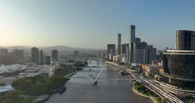 4K Aerial Push in tracking shot of west side of Brisbane City CBD also known as South Bank Precinct with new buildings and a new pedestrian bridge called Neville Bonner Bridge, Brisbane, QLD,Australia
