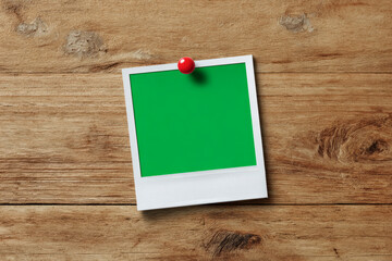 Vintage polaroid frame pinned to rustic wood background for creative design projects and personal messages