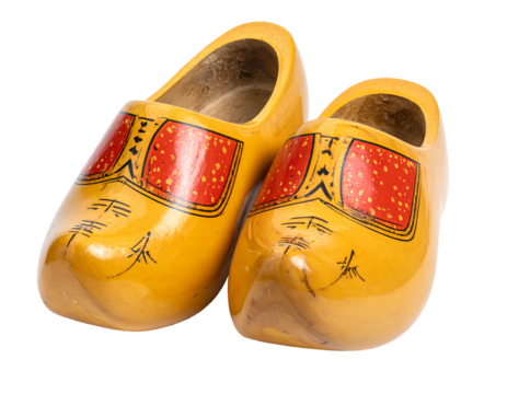 Yellow wooden clogs with red and black decorative elements resting on a solid black background
