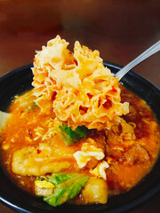 Delicious Traditional Javanese Cuisine Seblak with Orange Red Broth and Savory Toppings