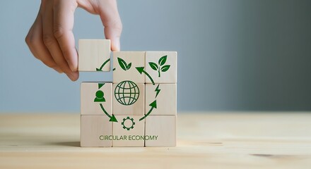 Hand building a recycling symbol with wooden blocks representing environmental sustainability and circular economy concepts