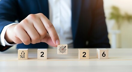 Business professional strategically placing a cube with a dollar sign to form the year twenty twenty six