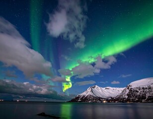 Dramatic northern lights illuminate a tranquil, snowy coastal mountain scene