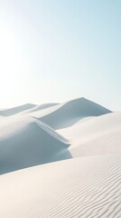 Sandy dunes under a light blue sky on a sunny day