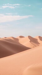 Sandy dunes under a light blue sky on a sunny day