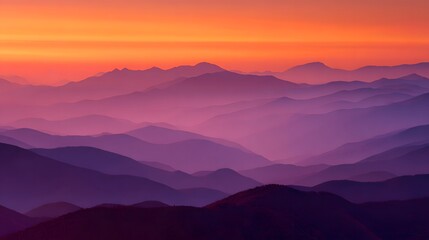 Fototapeta premium Layered mountain ridges display vibrant purple and orange hues during twilight illumination