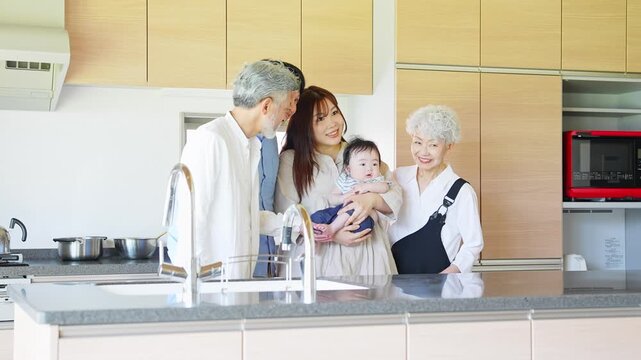 A smiling three-generation family surrounding a baby