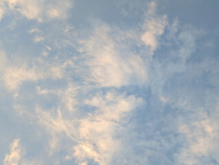 Serene Sky with Wispy Clouds illuminated by Soft Sunlight