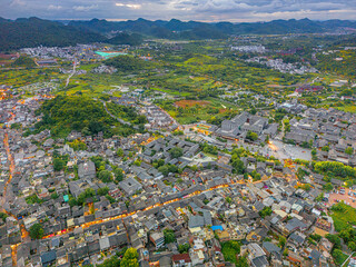 Dramatic light over Qingyan Ancient Town, one of the top 4th famous old towns and popular travel destination in Guizhou Province, China, aerial drone shot