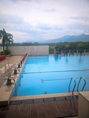 Corner View of Outdoor Swimming Pool with Tropical Mountain Background