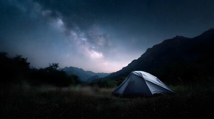 Obraz premium A tent is pitched in a mountain meadow under the vast starry Milky Way at night