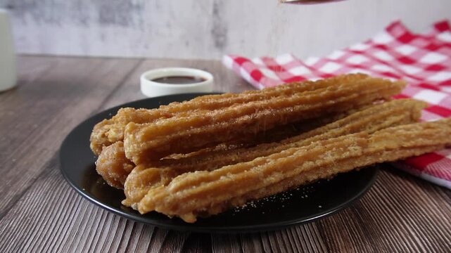 Slowly pour sugar and cinnamon over churros. Mexican food