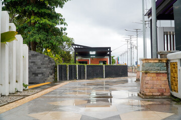 A wet, overcast day with a view of a modern building and surrounding structures.