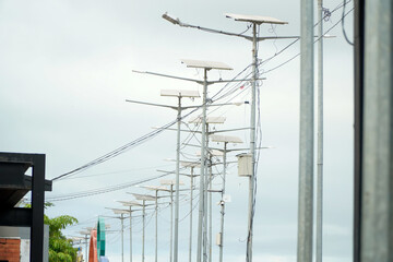 Row of solar powered street lights against a cloudy sky.